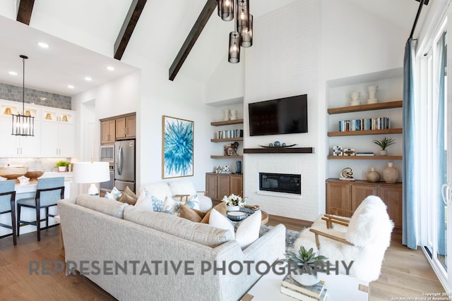 living room featuring high vaulted ceiling, a fireplace, light wood-type flooring, beam ceiling, and built in shelves