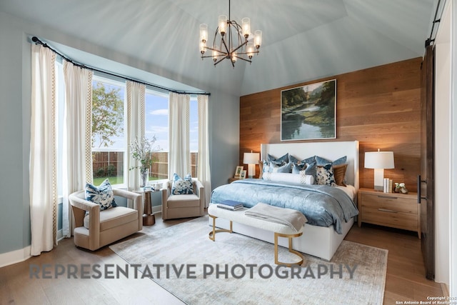 bedroom with vaulted ceiling, hardwood / wood-style floors, a notable chandelier, and wood walls