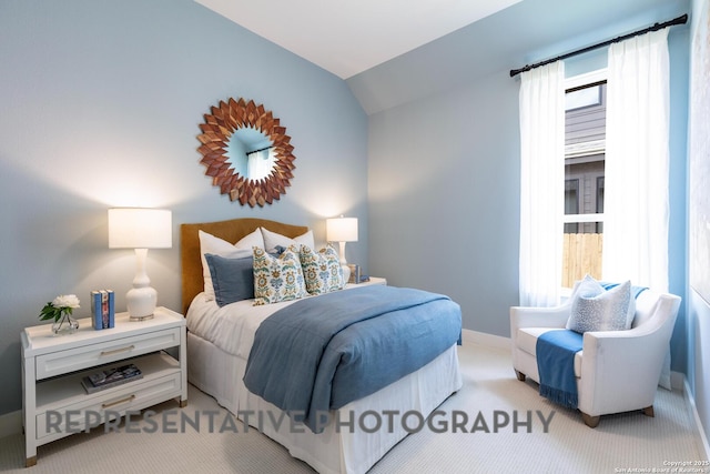 bedroom with vaulted ceiling and light colored carpet