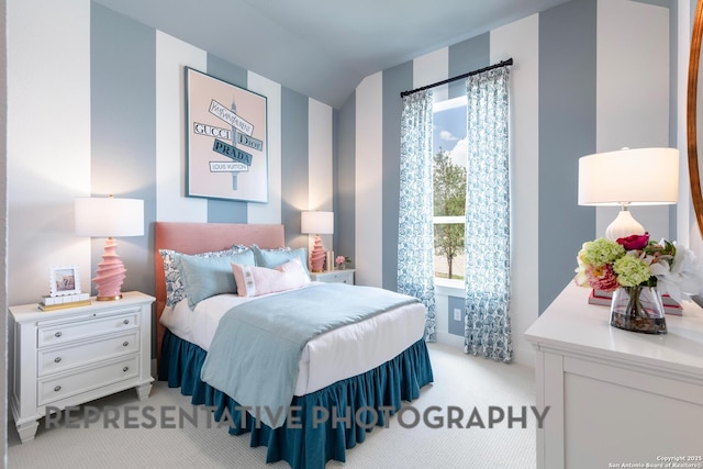 bedroom featuring vaulted ceiling and light colored carpet