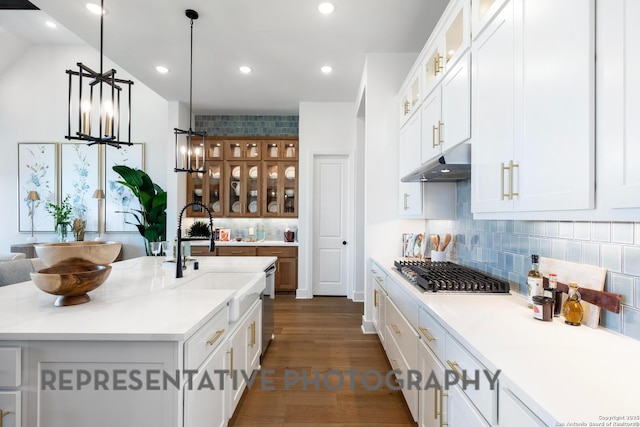 kitchen with sink, stainless steel gas cooktop, white cabinets, a center island with sink, and decorative light fixtures