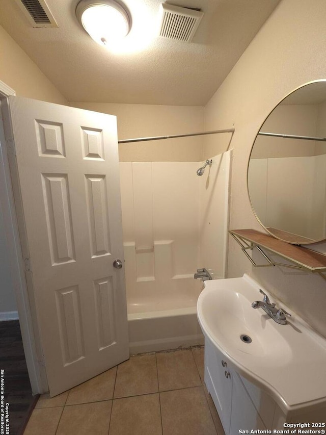 bathroom featuring shower / tub combination, tile patterned floors, a textured ceiling, and vanity