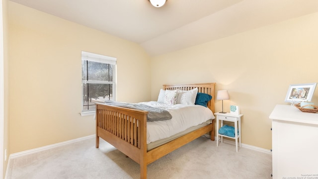 carpeted bedroom with lofted ceiling