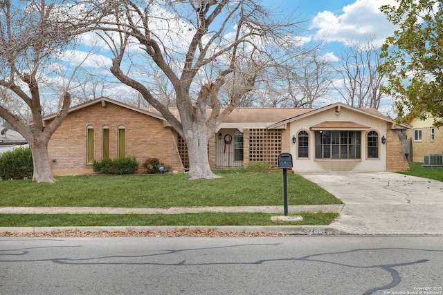 single story home with cooling unit and a front yard