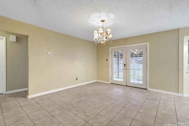 tiled spare room with french doors, a textured ceiling, and a notable chandelier