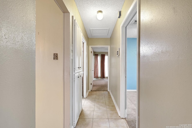 corridor with light tile patterned floors and a textured ceiling