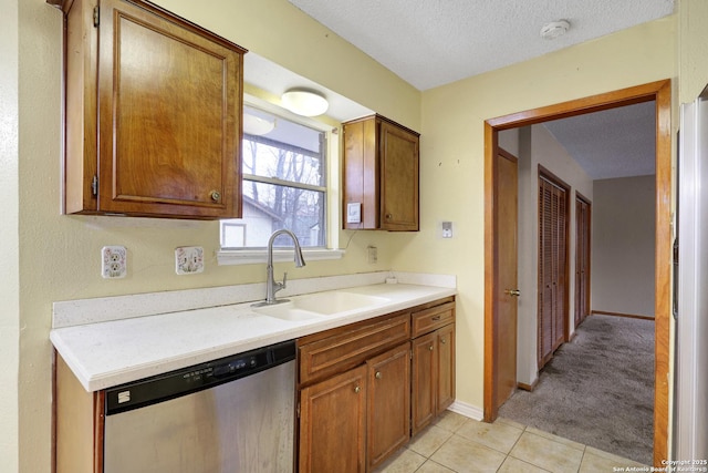 kitchen featuring sink, light tile patterned floors, stainless steel appliances, and a textured ceiling