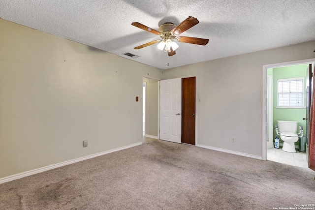 unfurnished room featuring ceiling fan, light colored carpet, and a textured ceiling