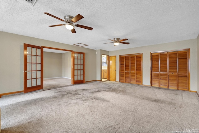 interior space with a textured ceiling, ceiling fan, and french doors