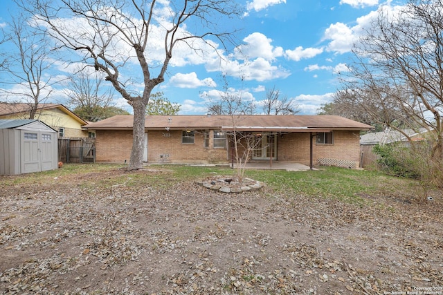 rear view of house featuring a shed, a patio, and an outdoor fire pit