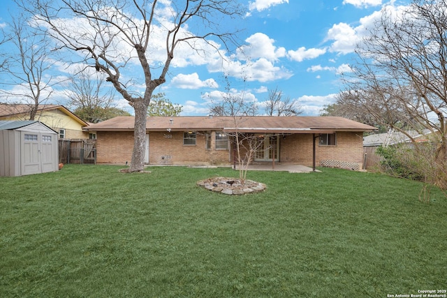 back of property featuring a storage unit, a yard, and a patio