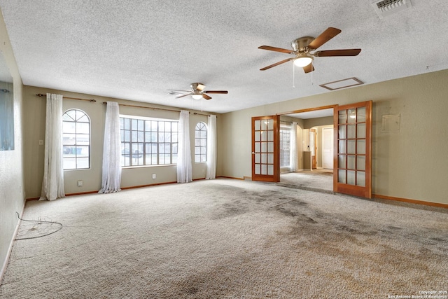 carpeted empty room featuring ceiling fan, a textured ceiling, and french doors