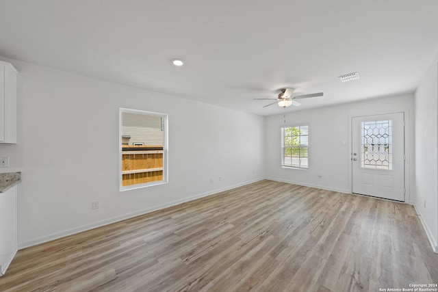 unfurnished living room featuring ceiling fan and light wood-type flooring