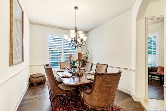 dining room with dark hardwood / wood-style flooring, ornamental molding, and an inviting chandelier