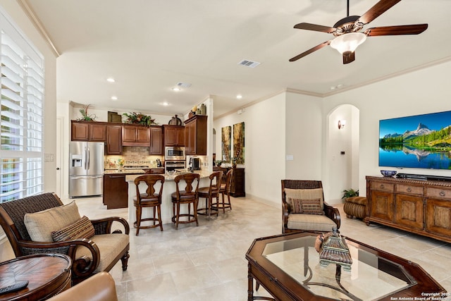 living room with ornamental molding and ceiling fan