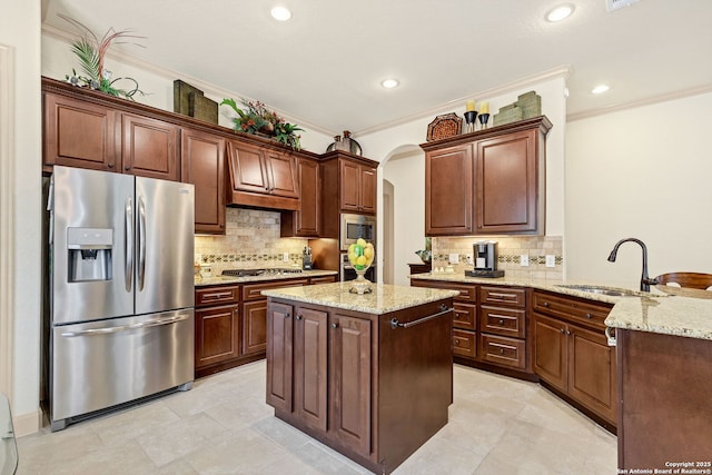 kitchen featuring appliances with stainless steel finishes, sink, ornamental molding, kitchen peninsula, and light stone countertops