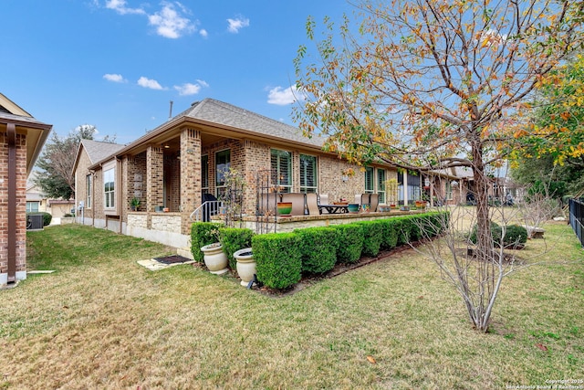 rear view of house featuring a yard, central AC, and a patio