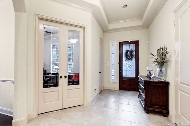 entryway featuring french doors, ornamental molding, a tray ceiling, and plenty of natural light