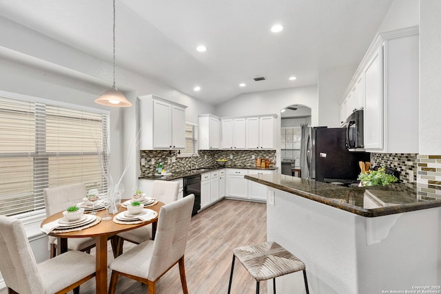 kitchen with light hardwood / wood-style flooring, black appliances, white cabinets, decorative light fixtures, and kitchen peninsula