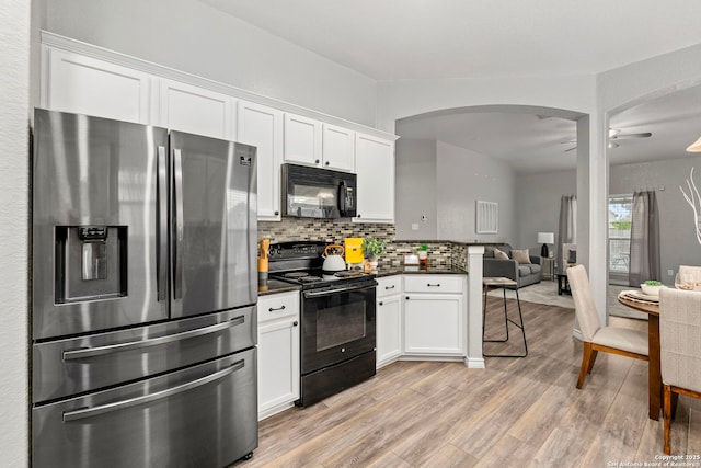 kitchen featuring light hardwood / wood-style flooring, ceiling fan, white cabinetry, black appliances, and decorative backsplash