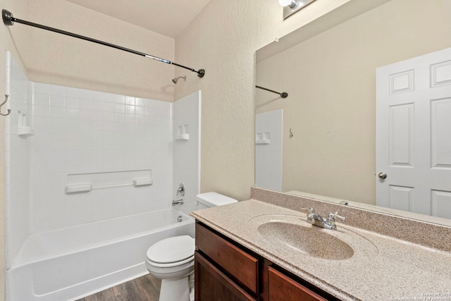 full bathroom featuring vanity, hardwood / wood-style flooring, bathing tub / shower combination, and toilet