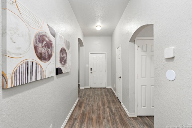 hallway featuring dark wood-type flooring and a textured ceiling