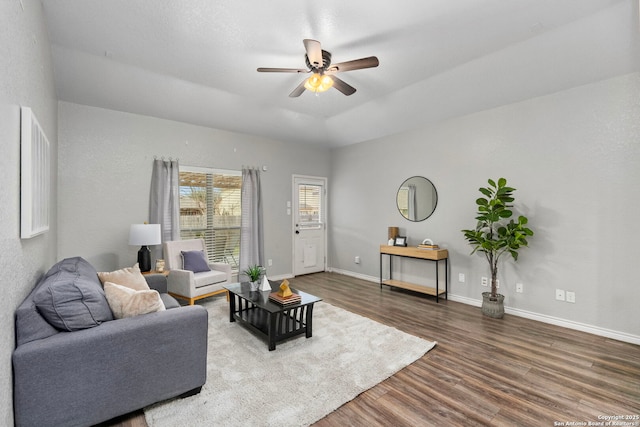 living room featuring dark wood-type flooring and ceiling fan