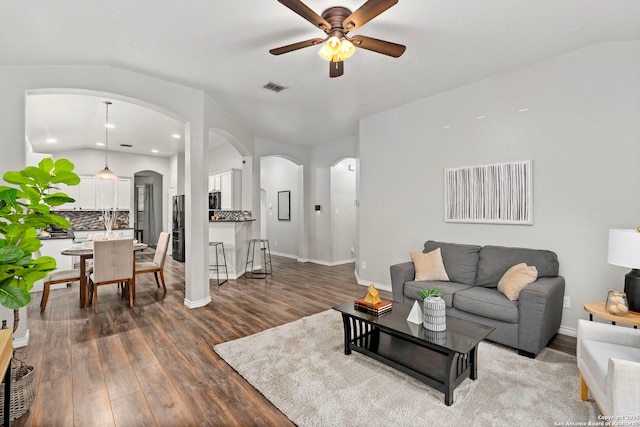 living room with dark wood-type flooring and ceiling fan