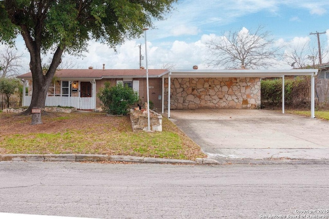 ranch-style home featuring a carport and a porch