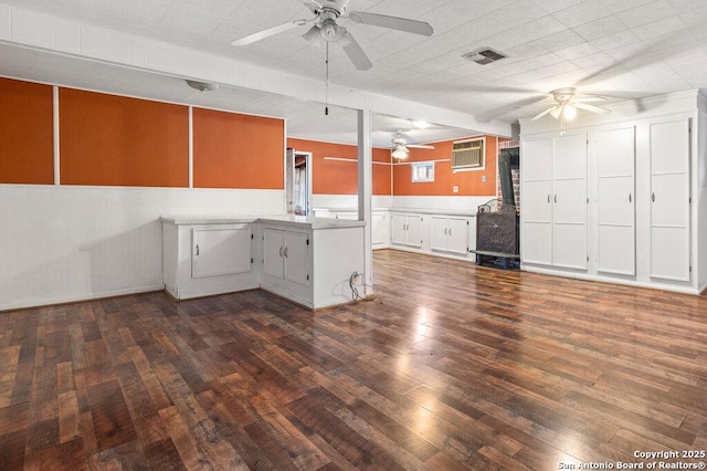 kitchen featuring an AC wall unit, dark hardwood / wood-style floors, white cabinetry, ceiling fan, and kitchen peninsula