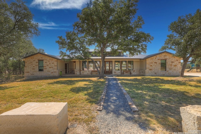 ranch-style home with covered porch and a front yard