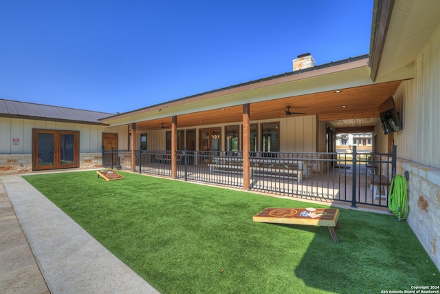 rear view of house with a lawn, french doors, and ceiling fan