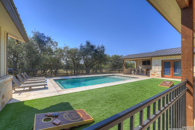 view of swimming pool with a lawn, a patio, and exterior bar