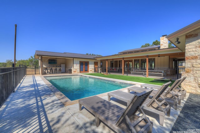 view of swimming pool featuring a patio area and a bar