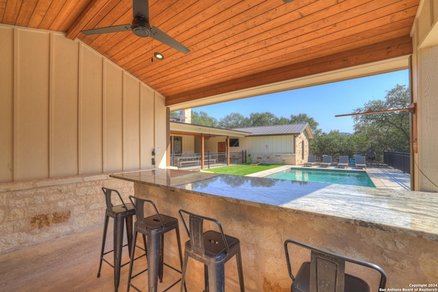 view of pool featuring a bar and ceiling fan