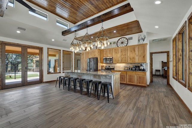 kitchen featuring french doors, decorative light fixtures, appliances with stainless steel finishes, a kitchen island, and backsplash