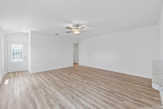 empty room with vaulted ceiling, ceiling fan, and light hardwood / wood-style flooring