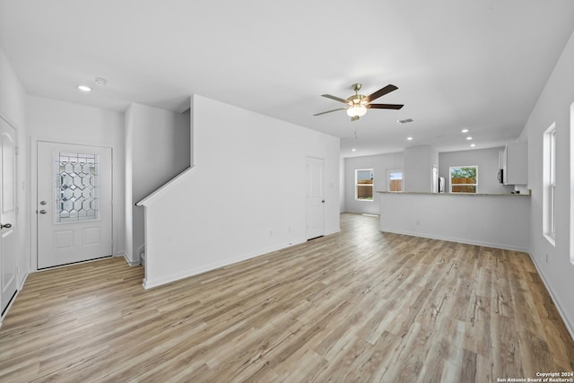 unfurnished living room featuring ceiling fan and light wood-type flooring