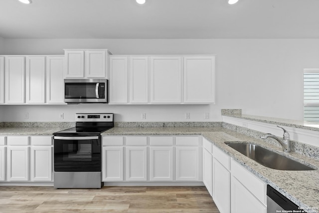 kitchen with appliances with stainless steel finishes, sink, and white cabinets