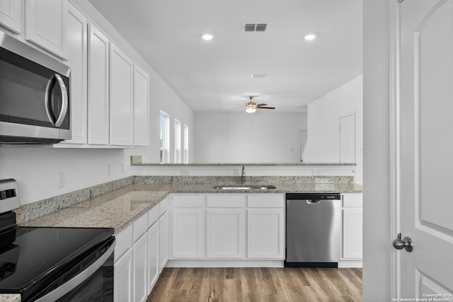 kitchen featuring sink, light hardwood / wood-style flooring, white cabinets, and appliances with stainless steel finishes