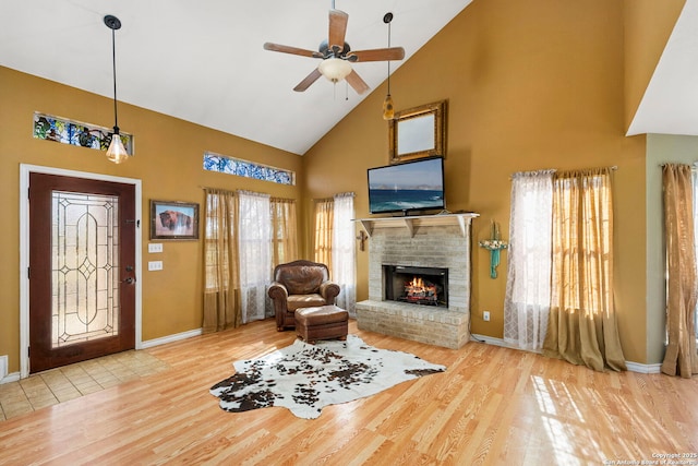 living room featuring ceiling fan, high vaulted ceiling, hardwood / wood-style floors, and a fireplace