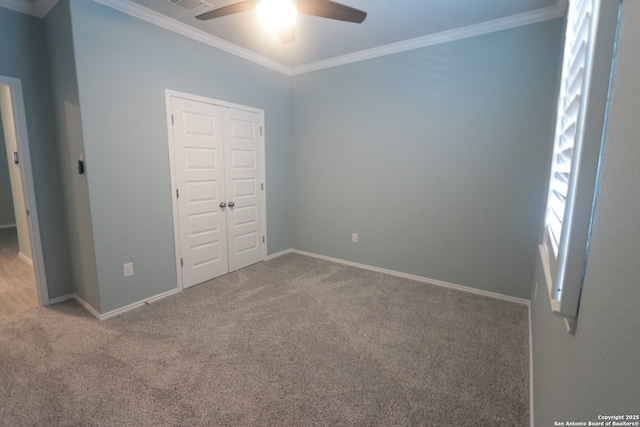 unfurnished bedroom with ceiling fan, ornamental molding, carpet flooring, and a closet