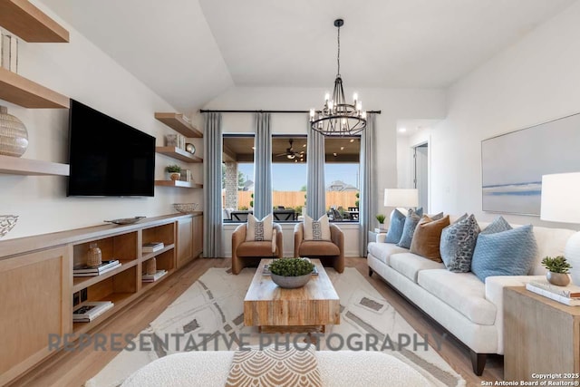 living room with vaulted ceiling, a chandelier, and light hardwood / wood-style floors