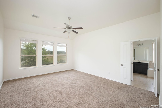 carpeted empty room featuring ceiling fan and vaulted ceiling