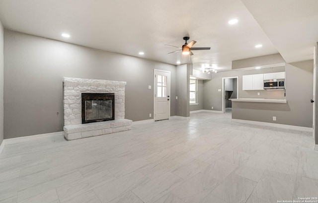 unfurnished living room with ceiling fan and a fireplace