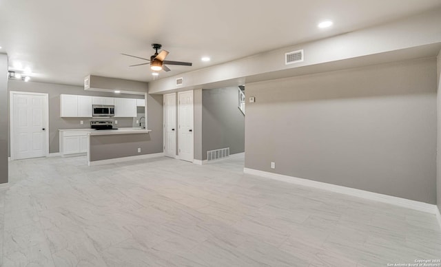 unfurnished living room featuring sink and ceiling fan