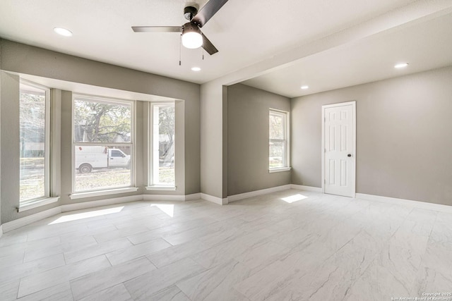 empty room featuring a wealth of natural light and ceiling fan