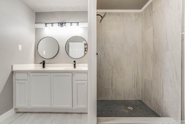 bathroom with crown molding, tiled shower, and vanity