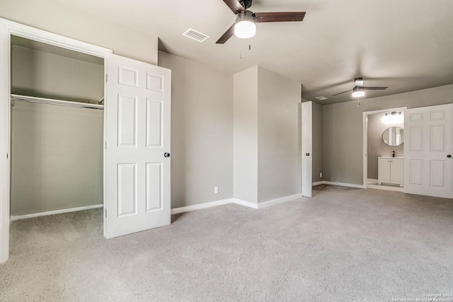 unfurnished bedroom with light carpet, ensuite bath, a closet, and ceiling fan