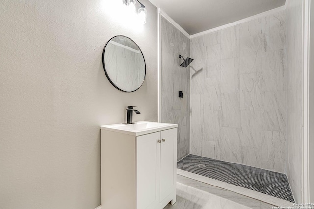 bathroom with crown molding, tiled shower, and vanity